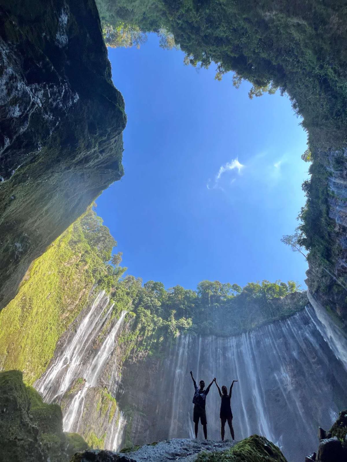 Travellers celebrating inside Tumpak Sewu waterfall canyon on a Florish Tour East Java trip